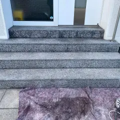 Treppenstufen aus Waschbeton werden mit Hausmitteln zum Naturstein versiegeln vorbereitet. Ein Schutzvlies liegt bereit.