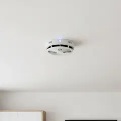 Ein weißer Hekatron Rauchmelder mit blauer LED piept ohne Grund an der Decke.