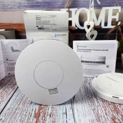 Rauchmelder für den Feueralarm ton, bereit zur Installation. Ein Rauchwarnmelder ProfessionalLINE liegt daneben.