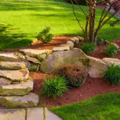 Ein schöner Garten gestalten mit wenig Geld: Steine, Rindenmulch und pflegeleichte Pflanzen schaffen eine natürliche Optik.