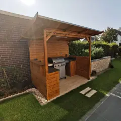 Ein schöner Grillunterstand, den man selber bauen kann, mit Gasgrill, Arbeitsfläche und gemütlicher Beleuchtung.