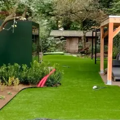 Ein schmal kleinen garten gestalten mit Kunstrasen, Holzpavillon und moderner grüner Wand.