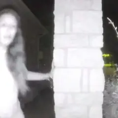 Eine Frau mit langen Haaren steht nachts vor einer Säule und fragt sich, wie sie reagieren, wenn es nachts klingelt.