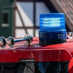 Blaulicht und Sirene auf einem roten Feuerwehrauto. Was kostet ein Feuerwehreinsatz bei Fehlalarm? Die Kosten können variieren.