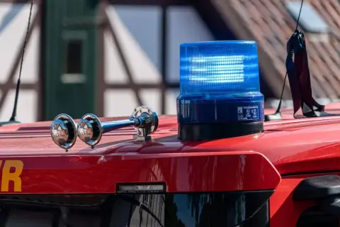 Blaulicht und Sirene auf einem roten Feuerwehrauto. Was kostet ein Feuerwehreinsatz bei Fehlalarm? Die Kosten können variieren.