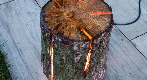 Eine einzigartige **Baumstamm Lampe selber machen** – ein Holzstamm mit leuchtenden Spalten, der Wärme und Gemütlichkeit ausstrahlt.