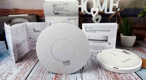 Rauchmelder für den Feueralarm ton, bereit zur Installation. Ein Rauchwarnmelder ProfessionalLINE liegt daneben.