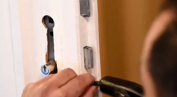 Mann versucht, ein Schloss zu reparieren, um zu wissen, was tun wenn man sich ausgesperrt hat.
