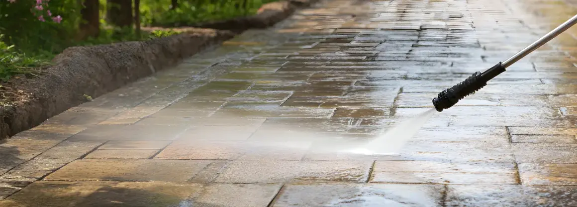 Hochdruckreiniger säubert Terrassensteine. Der Wasserstrahl entfernt Schmutz und lässt die Steine wieder wie neu aussehen.