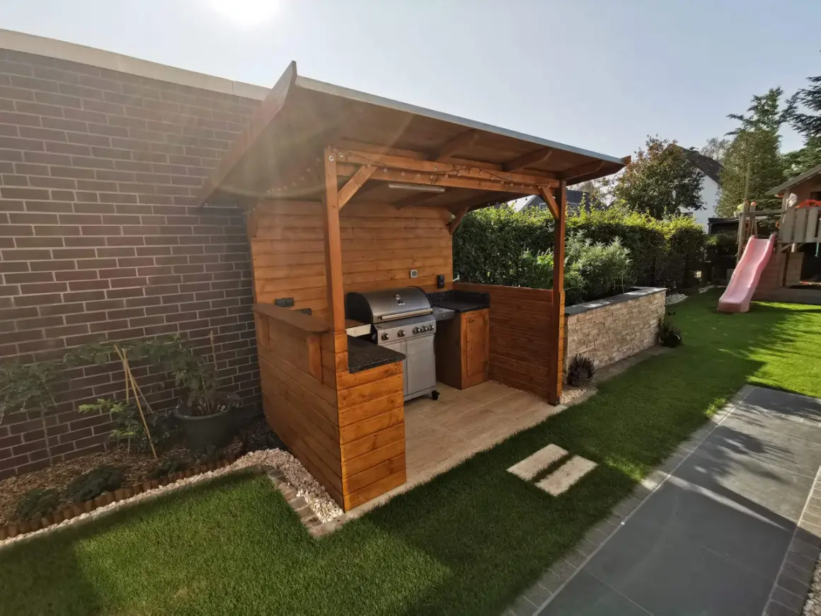 Ein schöner Grillunterstand, den man selber bauen kann, mit Gasgrill, Arbeitsfläche und gemütlicher Beleuchtung.