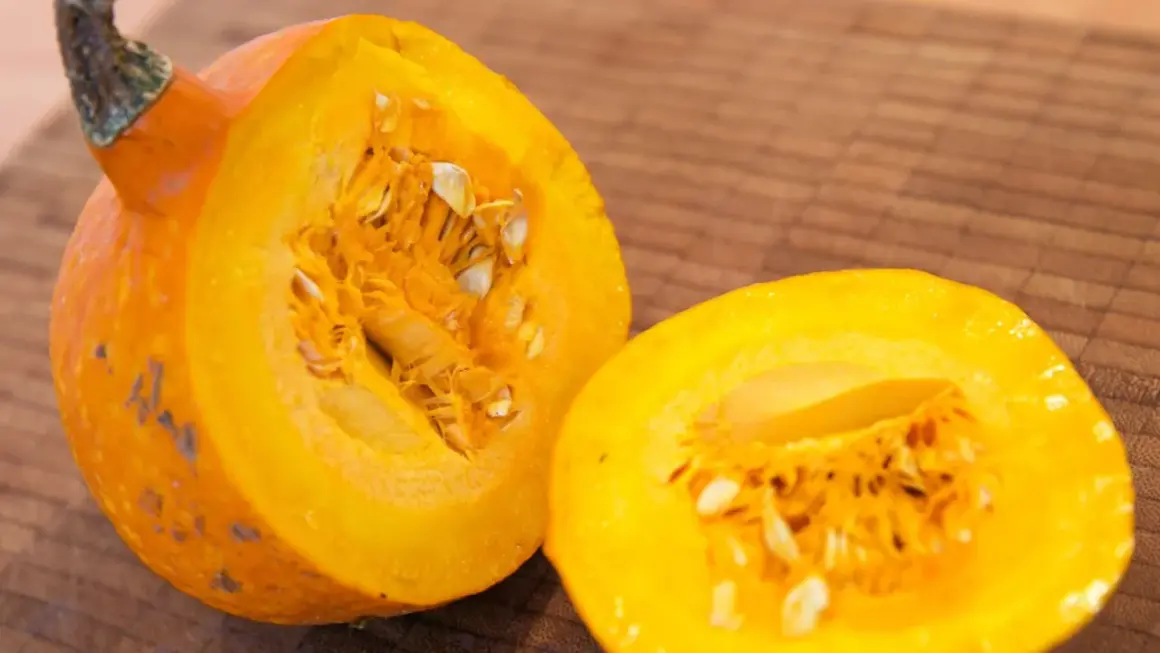 Eine leuchtend orangefarbene Hokkaido-Kürbishälfte liegt neben der anderen, bereit für die Ernte und Zubereitung.
