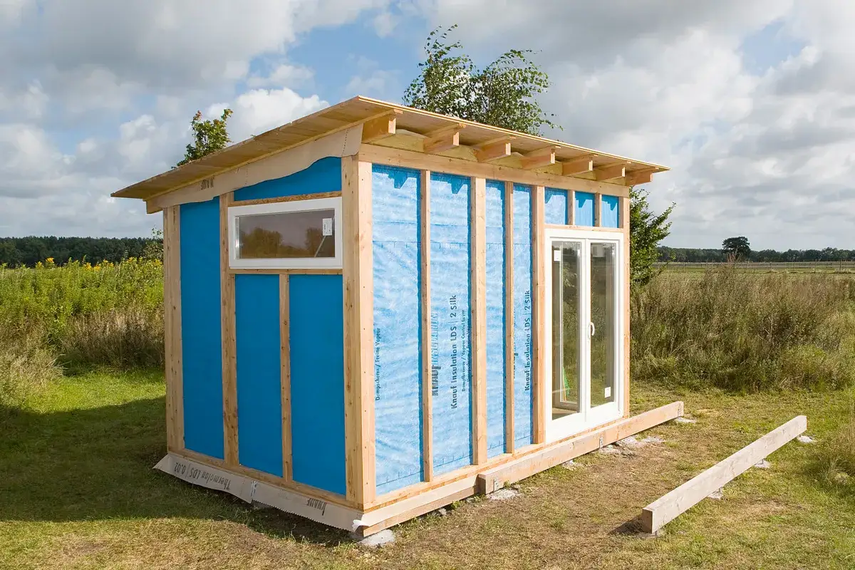 Ein im Bau befindlicher Schuppen mit blauer Dampfsperre und Holzrahmen. Perfekt f&uuml;r alle, die einen Schuppen selber bauen m&ouml;chten.